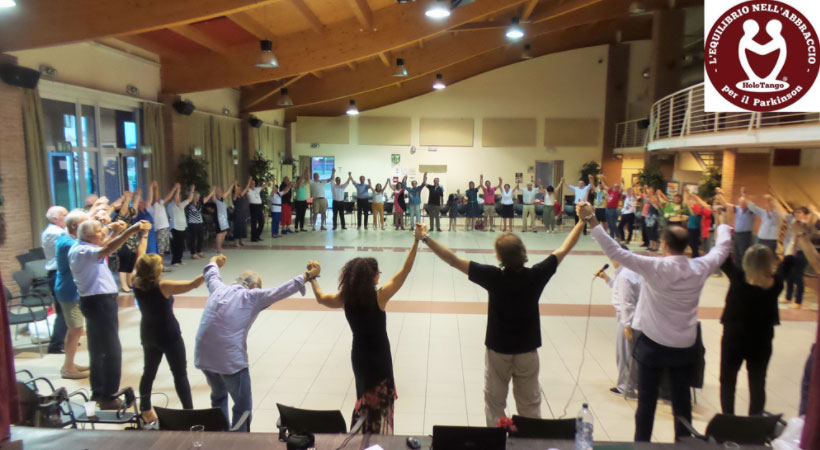 gruppo di persone in palestra si salutano con mani alzate